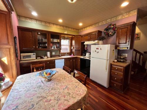 a kitchen with a table and a white refrigerator at Gwen's Place - Private 2nd Floor in Saint Ansgar
