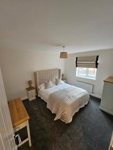 a bedroom with a large white bed with a window at Oakmere Apartments in Chinley