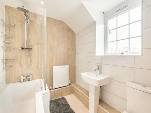 a bathroom with a sink and a tub and a toilet at Dovedale Cottage in Coningsby