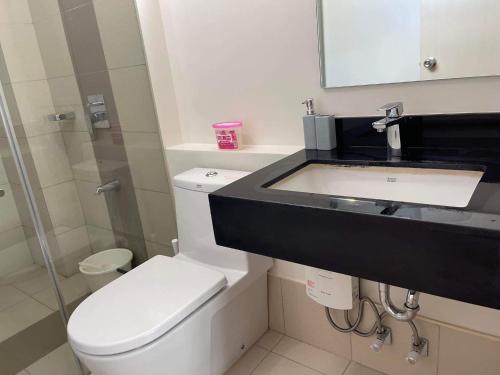 a bathroom with a white toilet and a sink at 2BR spacious stylish condo near mall in Cebu City