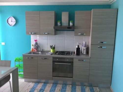a kitchen with wooden cabinets and a stove top oven at Baia di Copanello IMMINENS MARI in Copanello