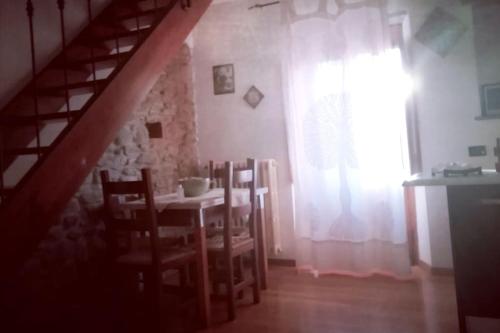 una sala da pranzo con tavolo, sedie e finestra di Appartamento tipico Toscano 4 posti letto a Rufina a Rufina