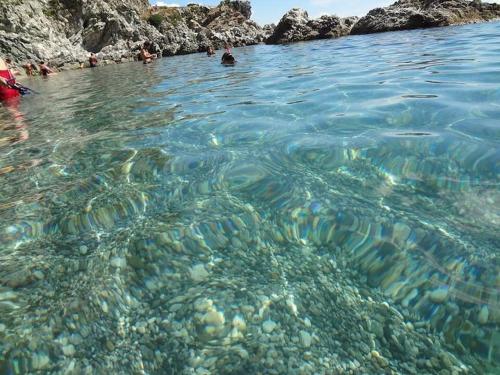 a group of people swimming in a body of water at Baia di Copanello IMMINENS MARI in Copanello
