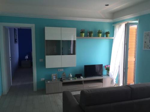 a living room with a couch and a television at Baia di Copanello IMMINENS MARI in Copanello
