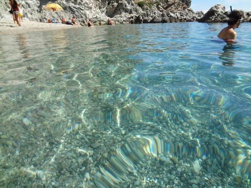 a boy swimming in the water near a beach at Baia di Copanello IMMINENS MARI in Copanello