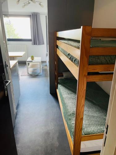 a room with bunk beds with a table and a window at studio 4 pers praloup 1600 in Uvernet-Fours