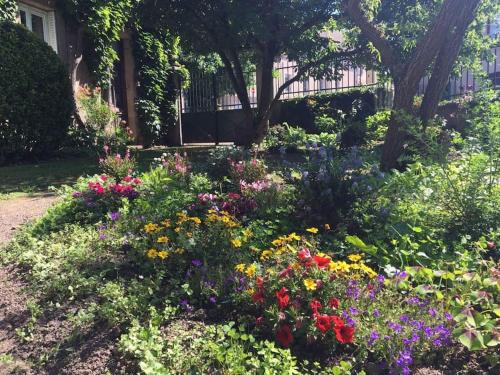 a garden of flowers in front of a house at Gîte de charme Autun'Home in Autun