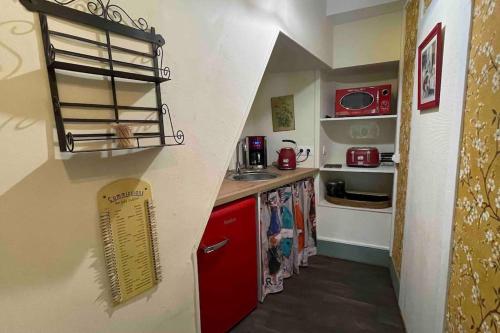 a small kitchen with a red refrigerator and a sink at Gîte de charme Autun'Home in Autun
