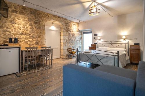 a bedroom with a bed and a kitchen and a living room at Cuturissi Hospitality & Wellness in Ragusa