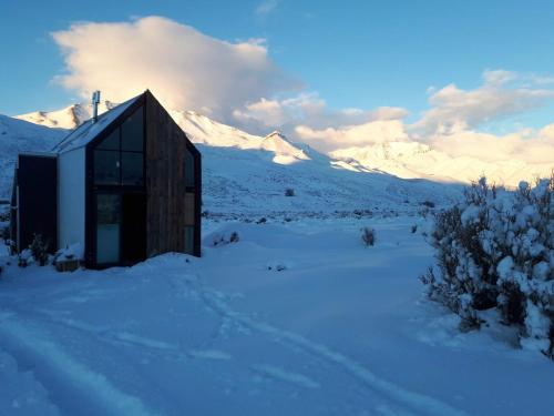 een huis in de sneeuw met bergen op de achtergrond bij Pueblo Andino Los Molles in Malargüe