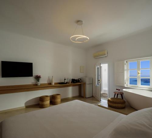 a living room with a tub and a television at Elia Family Suites in Fira