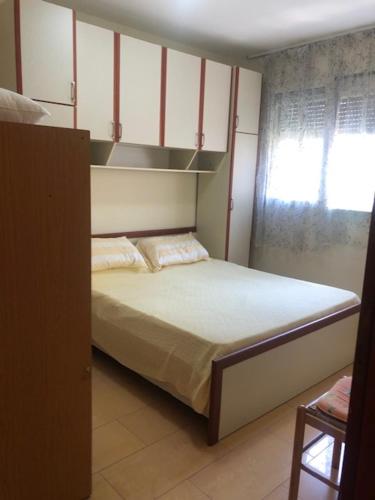 um pequeno quarto com uma cama e uma janela em Lili's House Golem, Durres em Golem