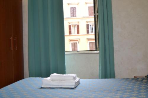 a bed with two towels sitting on top of it at Bye Rome Guesthouse in Rome