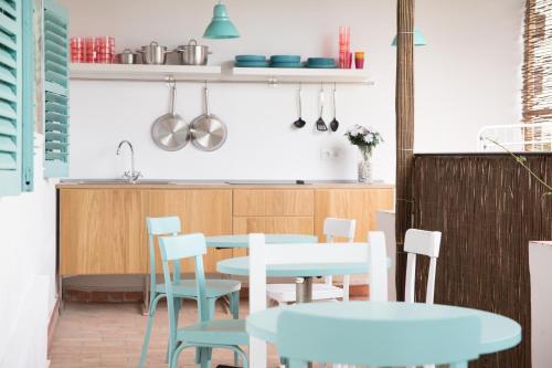 una cocina con mesas y sillas azules y blancas en Guest House Ibiza, en San Antonio