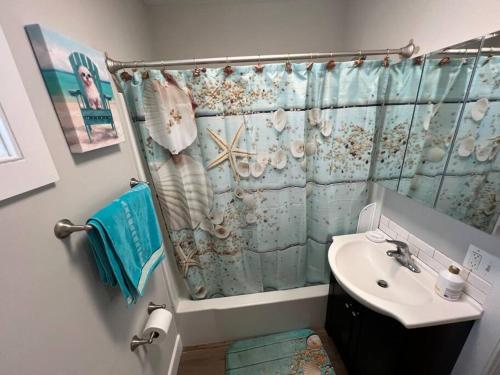 a bathroom with a shower curtain and a sink at 1BR/BA Condo w/Patio - 8 min to Wildwood Beach/Boardwalk in Wildwood