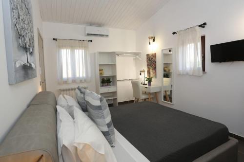 a bedroom with a bed and a desk in a room at Alpaca Etna Rooms da Mariagiovanna in Linguaglossa