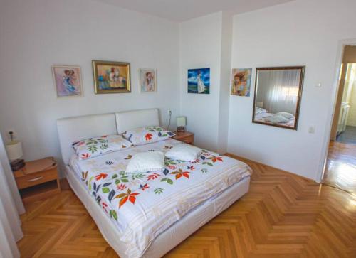 a bedroom with a white bed with flowers on it at AMAZING VIEW NEAR THE CITY CENTER in Split