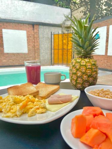 uma mesa com um prato de comida para o pequeno-almoço e um ananás em Hotel Torre del Viento cali em Cali