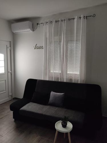a black couch in a living room with a window at AMI in Solin