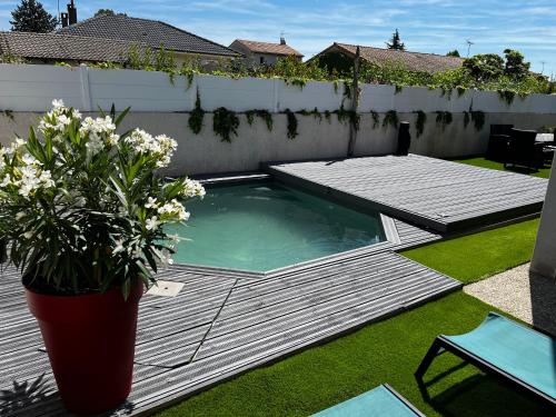 una pequeña piscina en un patio con un jarrón de flores en La Maison de Jade, en La Roche-de-Glun