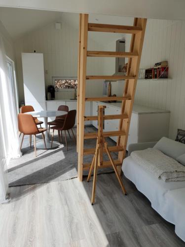 Habitación con escalera, mesa y sillas en The Black and White cabin with Spa bath en Västra Torup