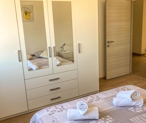 a bedroom with a large white cabinet with towels on a bed at Apartment Mare in Pula