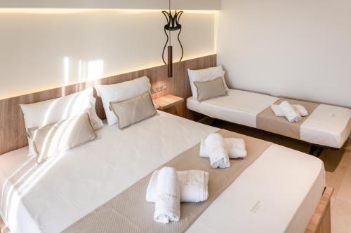 a bedroom with two beds with towels on them at Pantheon Sea View in Nei Poroi