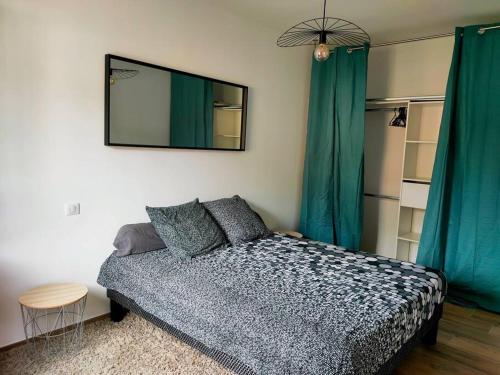 1 dormitorio con cama y espejo en la pared en Appartement neuf avec balcon et 2 chambres en Saint-Florent