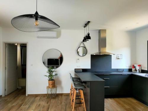 a kitchen with a black counter top and a table at Appartement neuf avec balcon et 2 chambres in Saint-Florent