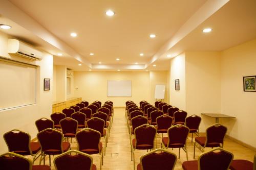 a conference room with chairs and a white screen at Ginger Nashik in Nashik