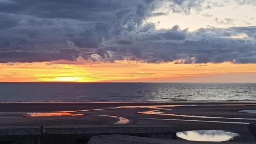 una puesta de sol en la playa con el océano en The Waldorf - Near Pleasure Beach & Sandcastle, en Blackpool