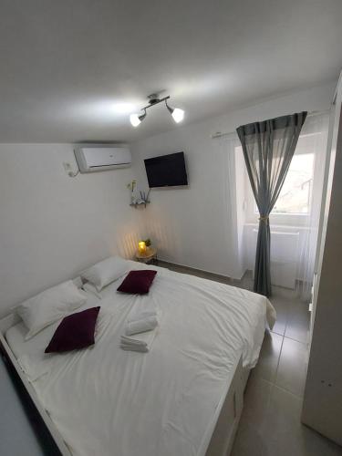 a white bed in a bedroom with a window at Vita in Bribir