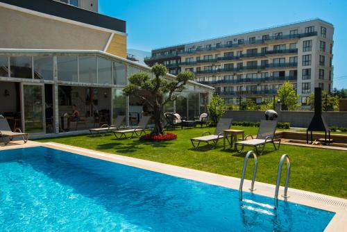 a swimming pool with chairs and a building at Royalova Hotel in Yalova