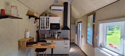 una pequeña cocina con mesa en una casa pequeña en BIRZI Parkside Lodge 