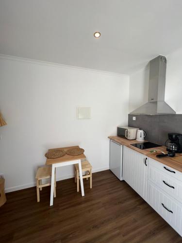 uma cozinha com uma pequena mesa e um fogão em Fishermans House em Almograve