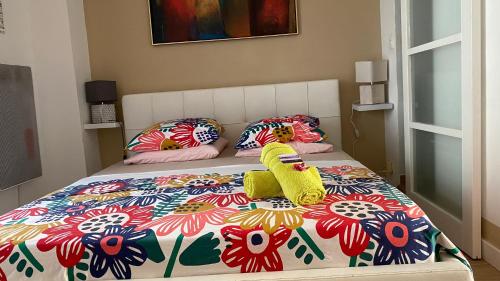 - un lit avec une couette et des oreillers colorés dans l'établissement Goeland 1, classé, climatisé, wifi terrasse ombragé de 12 m2 à 150 m de la plage, à Toulon