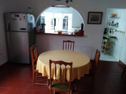 a kitchen with a table with chairs and a refrigerator at UMI SUSHI HOUSE in Huanchaco