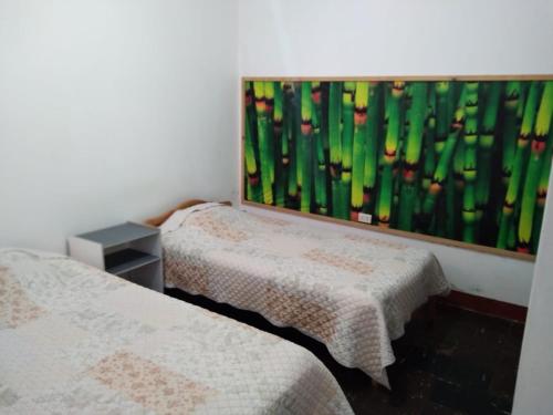 2 Betten in einem Zimmer mit Wandgemälde in der Unterkunft UMI SUSHI HOUSE in Huanchaco
