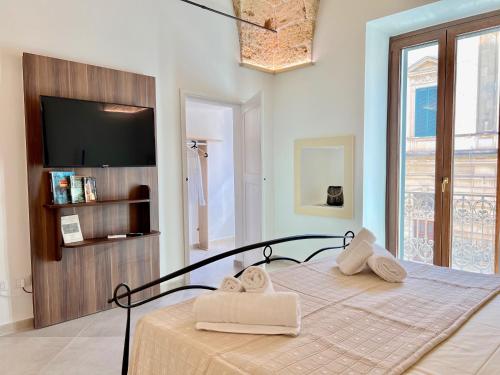 een slaapkamer met een bed met handdoeken erop bij Suite La Basilica in Galatina