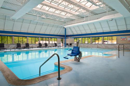 a swimming pool with a blue chair in a building at The English Inn of Charlottesville in Charlottesville