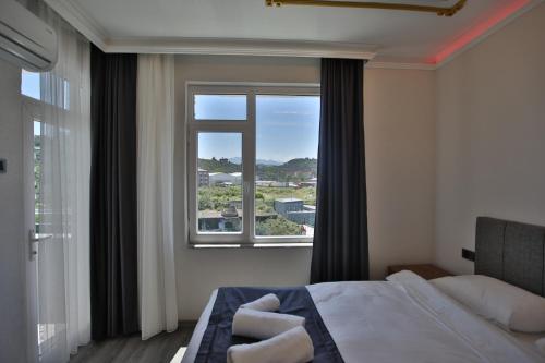 a bedroom with a bed and a large window at Black Pearly Hotel in Trabzon