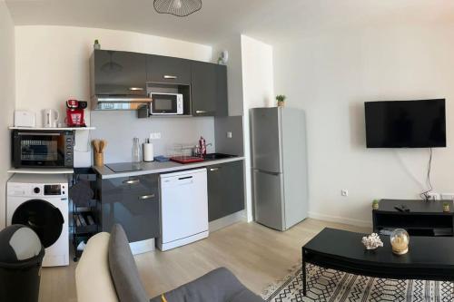 eine Küche mit Küchengeräten aus Edelstahl im Wohnzimmer in der Unterkunft Bel appart T2 idéalement situé in Bondy