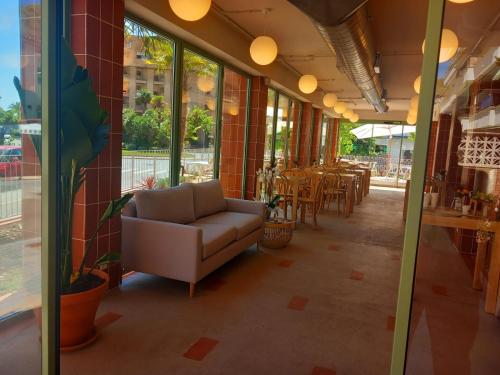 een woonkamer met een bank, tafels en ramen bij Terra Aurea Aparthotel in Salou