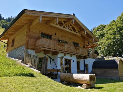 a wooden house with a balcony on top of it at Riedlfeld Chalet in Dienten am Hochkönig