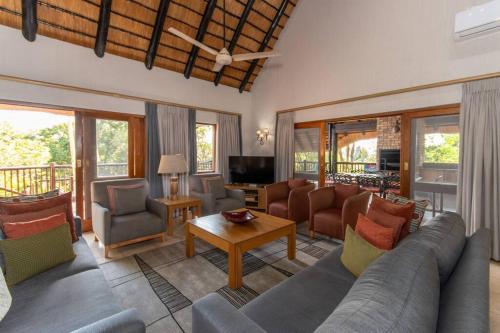 a living room with a couch and chairs and a table at Kruger Park Lodge Unit No 308 with private pool - NYALA LODGE in Hazyview