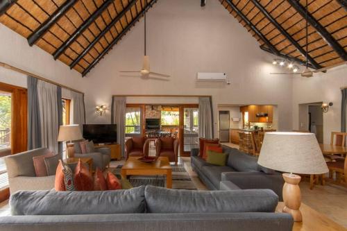 a large living room with couches and a living room with at Kruger Park Lodge Unit No 308 with private pool - NYALA LODGE in Hazyview