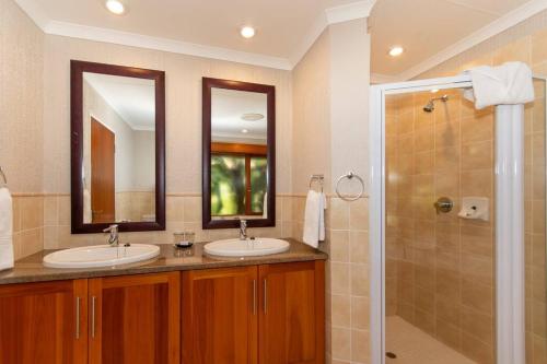 a bathroom with two sinks and a shower at Kruger Park Lodge Unit No. 308 in Hazyview