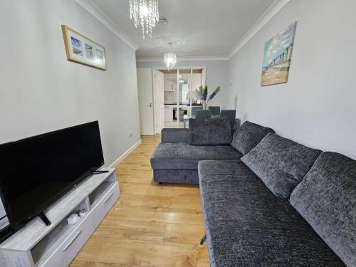a living room with a couch and a flat screen tv at Lovely Flat close to Shepherd's Bush in London