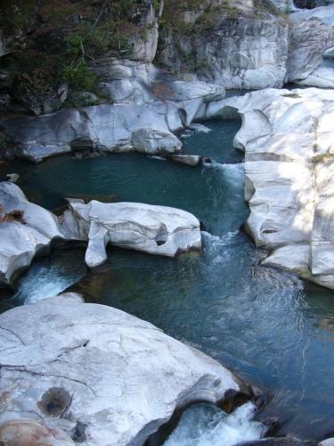 a stream of water with rocks in the middle at Giuditta FreeCarPark&Garden in Domodossola