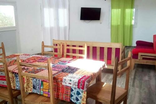 a bedroom with a table and chairs and a television at La case ronde avec Piscine -Ndayane in Ndayane